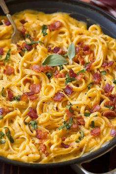 a pan filled with pasta and topped with bacon