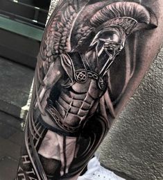 a man's arm with a spartan tattoo on it