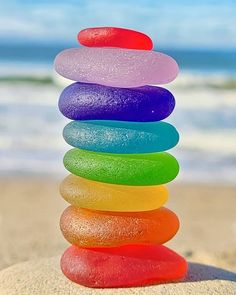 a stack of colorful rocks sitting on top of a sandy beach