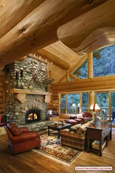 a living room with wood floors and a stone fire place in the middle of it