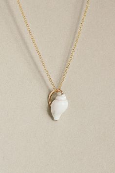 Petite white Nassa seashell, clutched by a 14k gold fill wire to make it a charm. Everyday White Hand-wrapped Jewelry, Adjustable Dainty Shell Jewelry, Handmade Dainty Shell-shaped Jewelry, Dainty Handmade Shell-shaped Jewelry, White Shell Jewelry With Ocean-inspired Style, Elegant Shell-shaped Rose Gold Jewelry, Elegant Rose Gold Shell-shaped Jewelry, Elegant Shell Jewelry With Lobster Clasp, White Shell Jewelry Gift