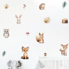 a baby's room with woodland animals on the wall