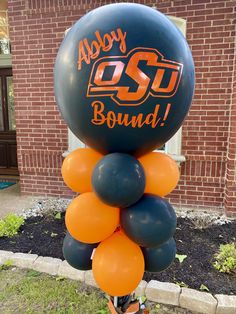 an orange and black balloon with the number twenty six on it in front of a brick building