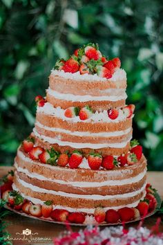 a three tiered cake with strawberries on top