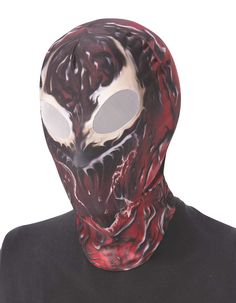 a man wearing a red mask with black and white designs on the face, in front of a white background