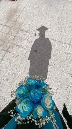 the shadow of a person standing next to a bouquet of flowers