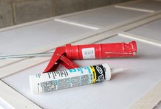 a pair of pliers and glue sitting on top of a white table with tile