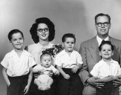 an old black and white photo of a family posing for a picture with their children