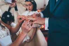 the bride and groom are exchanging their wedding rings