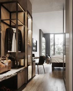 an open closet with clothes and luggage on the shelves next to a bed in a bedroom