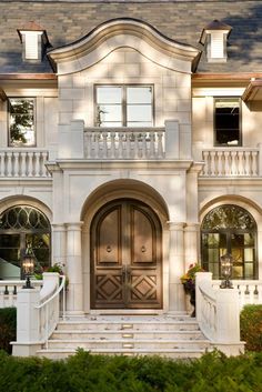 a large white house with stairs leading up to the front door