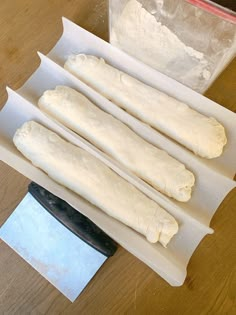 four uncooked dough sticks sitting on top of a piece of paper