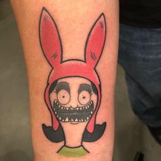 a person with a tattoo on their leg wearing a red bunny mask and black mustache