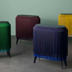 three different colored stools sitting next to each other