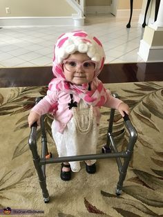 a baby doll sitting on top of a metal chair in front of a carpeted floor