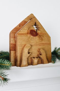 a wooden nativity scene is displayed on a mantle