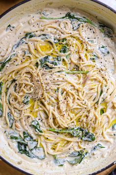 pasta with spinach and white sauce in a pan