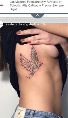 a woman's stomach with a bird tattoo on it