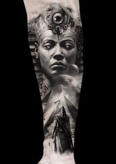 an arm tattoo with the egyptian god and pyramids in black and grey ink on it