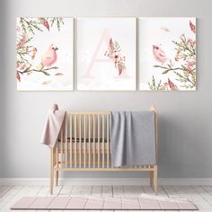 a baby's room with two pink and white paintings on the wall, one is in