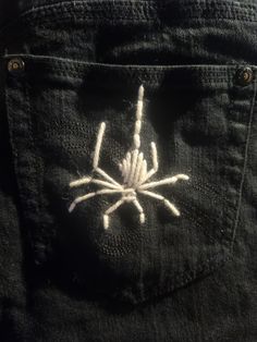 a spider embroidered on the back of a pair of jeans