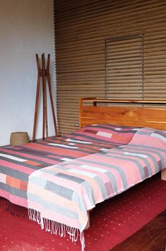 a bed with a blanket on top of it next to a wooden headboard and foot board