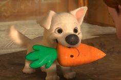 a white dog holding a carrot in it's mouth while standing next to a little boy