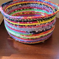 a multicolored basket sitting on top of a wooden table