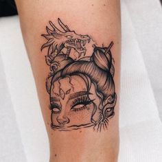 a woman's face with dragon and skull tattoos on her leg, as well as an eyeball