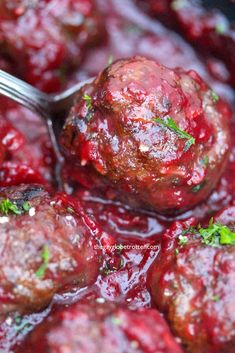 cranberry meatballs with sauce and fresh herbs are ready to be eaten in the slow cooker