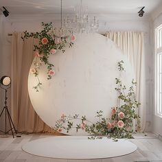 a large white circle with pink flowers on it in front of a chandelier