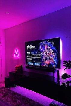 a living room with purple lighting and a flat screen tv mounted on the wall in front of it