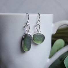 Not only is it a chore to make sea glass earrings, but it is also a bigger challenge to find 2 pieces of sea glass that are similar enough to make a decently matching pair of earrings. Here are the details about these bright green earrings: I used 2 pieces of green sea glass from the UK set in sterling and fine silver and attached to handmade recycled stud earrings. All of our sea glass is found and not altered in any way. This item was handmade by Barb Macy in Corvallis, OR. Green Jewelry With Matching Earrings For The Beach, Sea Glass Teardrop Earrings As Gift, Teardrop Sea Glass Earrings For Gift, Handmade Green Jewelry From Recycled Glass, Green Sterling Silver Single Earring, Handmade Silver Earrings With Sea Glass, Sea Glass Dangle Earrings With Matching Set, Handmade Green Recycled Glass Jewelry, Teardrop Sea Glass Earrings With Ear Wire