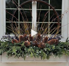 a window sill decorated with pine cones and berries