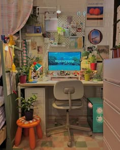 a desk with a computer on top of it in a room filled with lots of plants