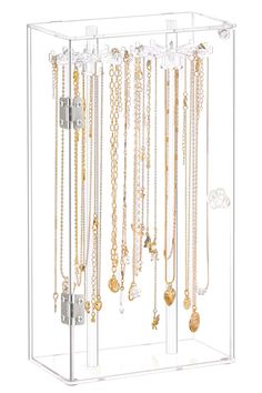 a clear display case with lots of necklaces hanging from it's sides,