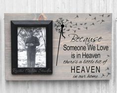 a wooden plaque with an image of a person holding a dandelion and saying because someone we love is in heaven there's a little bit of heaven at our home