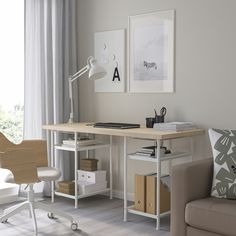 a desk with a chair, lamp and pictures on the wall in front of it