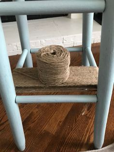 a roll of twine sitting on top of a wooden chair