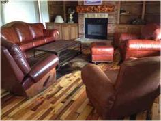 a living room filled with brown furniture and a fire place in the middle of it