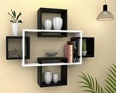 three black and white shelves with vases, bookshelves and other items on them