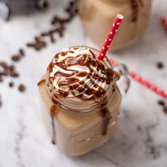 two iced coffees with whipped cream and chocolate drizzled on the top