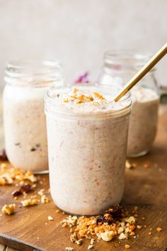 two jars filled with food sitting on top of a wooden table next to each other