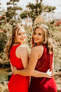 two women in red dresses hugging each other