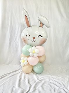 a balloon bunny holding flowers and balloons