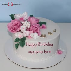 a white cake with pink flowers and the words happy birthday any name here on it