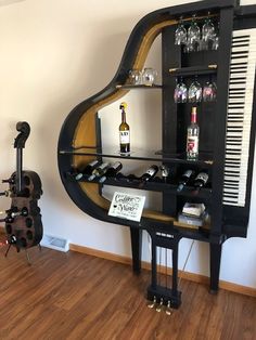 a piano shaped shelf with wine glasses and bottles on it