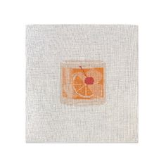 an orange slice is shown on the side of a piece of white fabric with a red apple in it