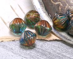 five glass beads sitting on top of a piece of paper next to an old mirror