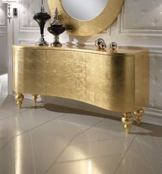 a large mirror sitting on top of a gold dresser